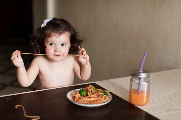 Adorable jovencita comiendo espagueti