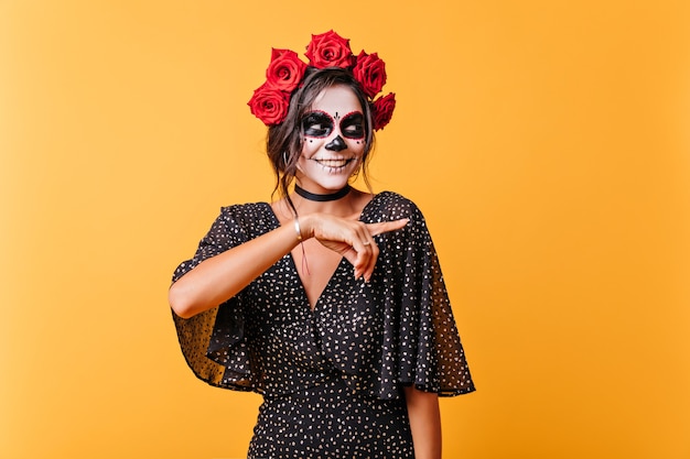 Adorable modelo de mujer mexicana disfrutando de halloween. Chica dichosa en traje de novia muerta expresando felicidad.