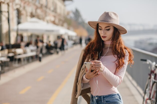 Adorable mujer en camisa rosa control de correo móvil