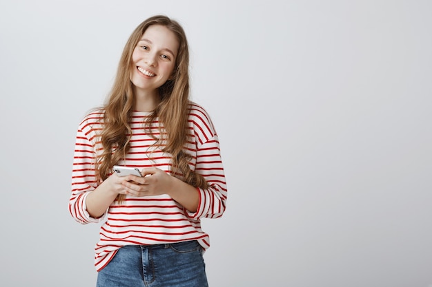 Adorable mujer sonriendo feliz y con smartphone