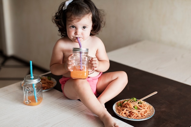 Adorable niña bebiendo jugo