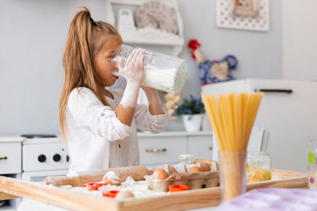 Adorable niña bebiendo leche