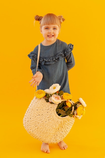 Foto gratuita adorable niña con cesta de flores