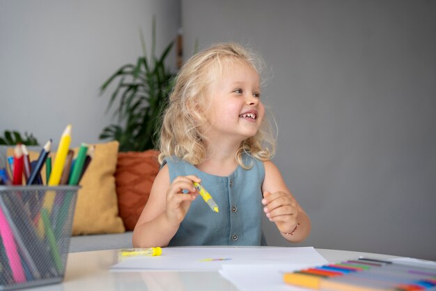 Adorable niña dibujando en papel en casa