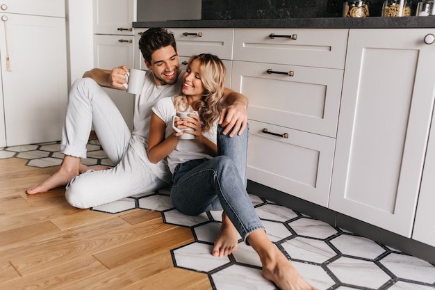 Foto gratuita adorable niña disfrutando del desayuno con su novio. hombre riendo tomando café con su esposa.