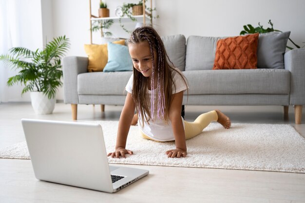 Adorable niña haciendo yoga en casa