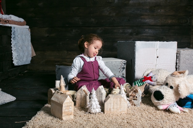 Adorable niña jugando con una casa hecha a mano