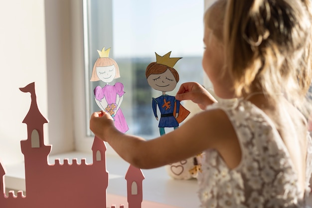 Adorable niña jugando con sus títeres en casa