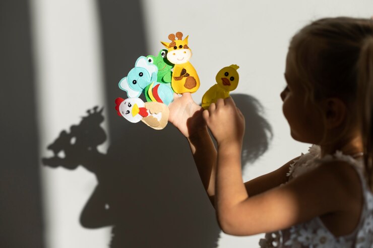 Foto gratuito adorable niña jugando con sus títeres en casa