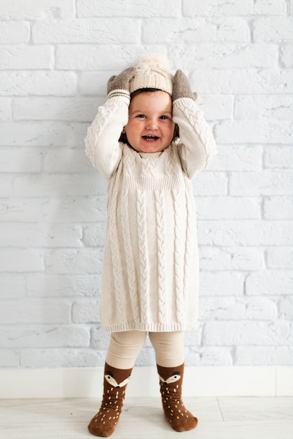 Foto gratuita adorable niña levantando su sombrero