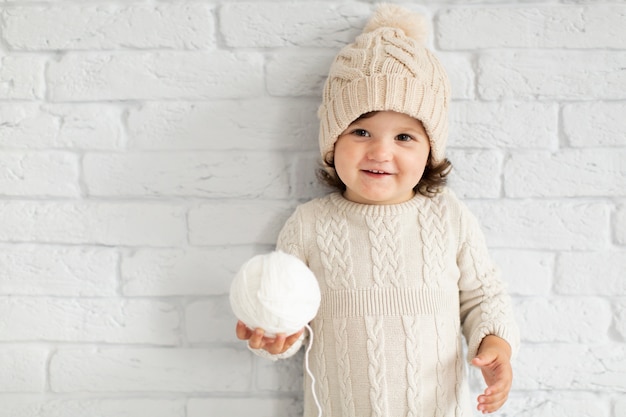 Foto gratuita adorable niña ofreciendo una bola de nieve