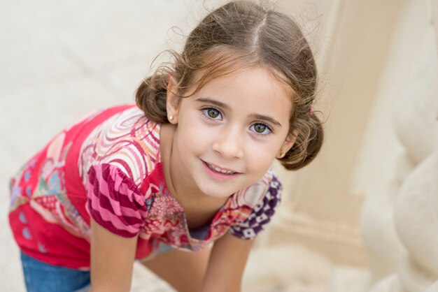 Adorable niña peinada con coletas al aire libre.