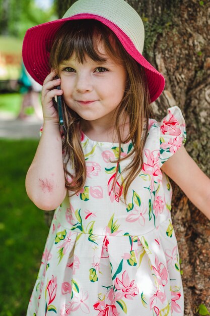 Adorable niña pequeña hablando por un teléfono móvil
