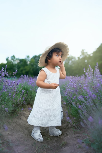 Adorable niña posando en campo lavanda