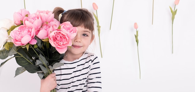 Adorable niña posando con rosas