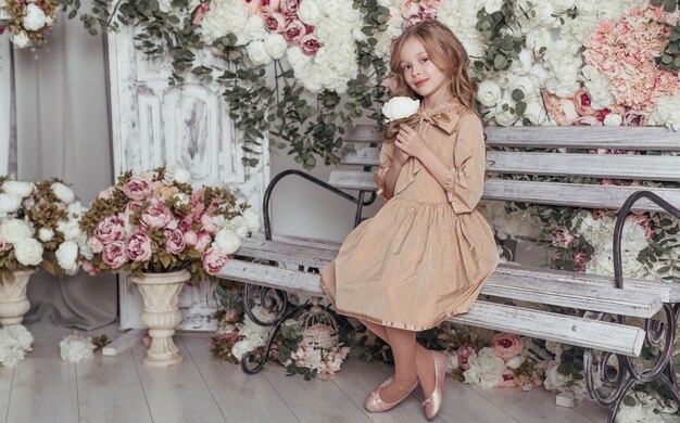 Adorable niña sentada en un banco