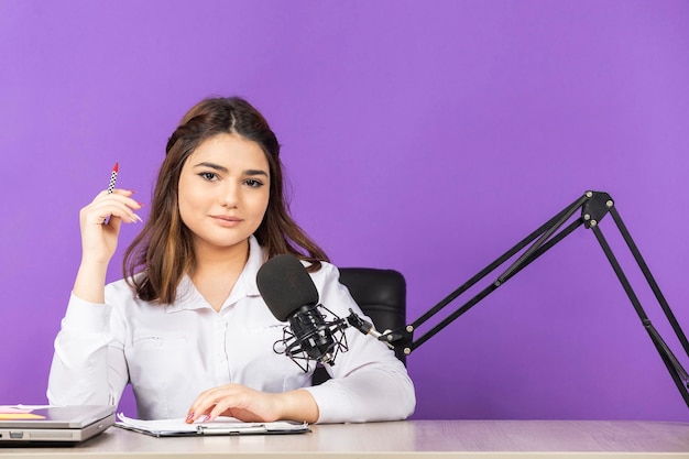 Foto gratuita adorable niña sentada detrás del escritorio y mirando a la cámara foto de alta calidad