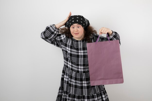 Adorable niña con síndrome de down con bolsa de compras.