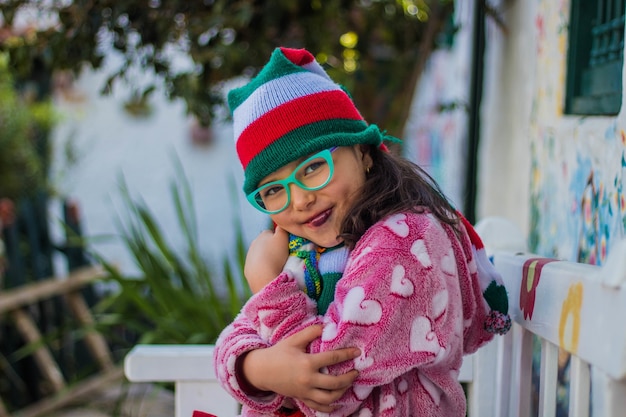 Adorable niña sonriendo y sosteniendo su muñeco de nieve