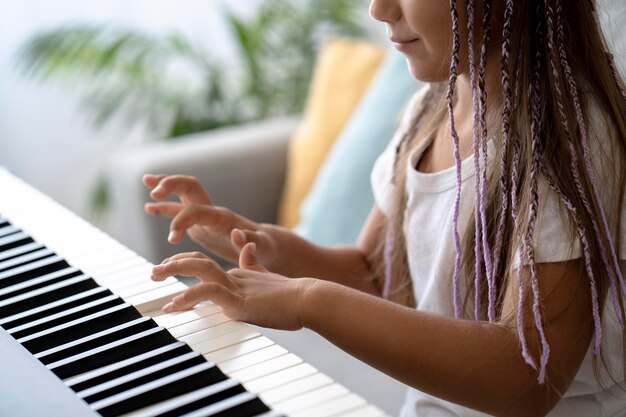 Adorable niña tocando el piano en casa