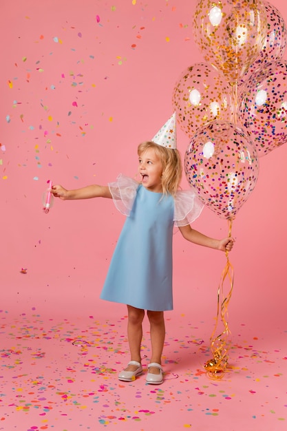 Adorable niña en traje con globos