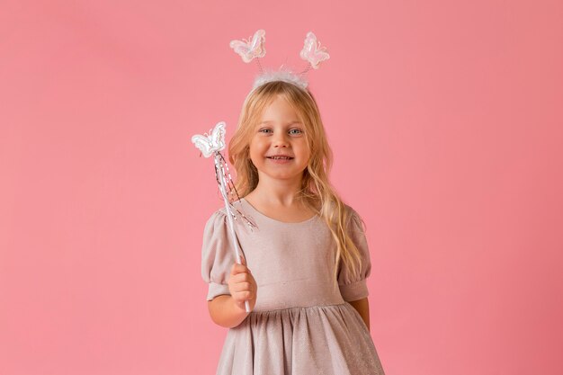 Adorable niña con varita en traje