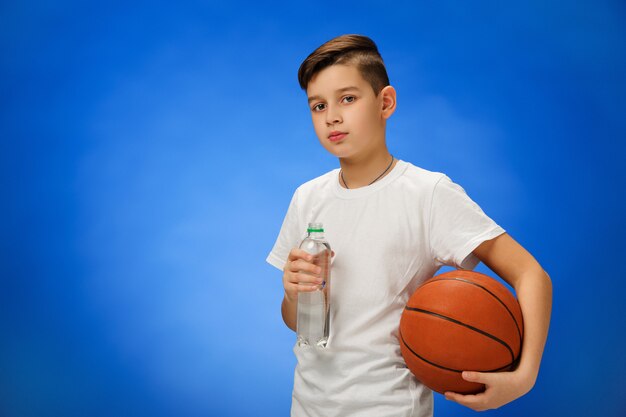 Adorable niño de 11 años con pelota de baloncesto