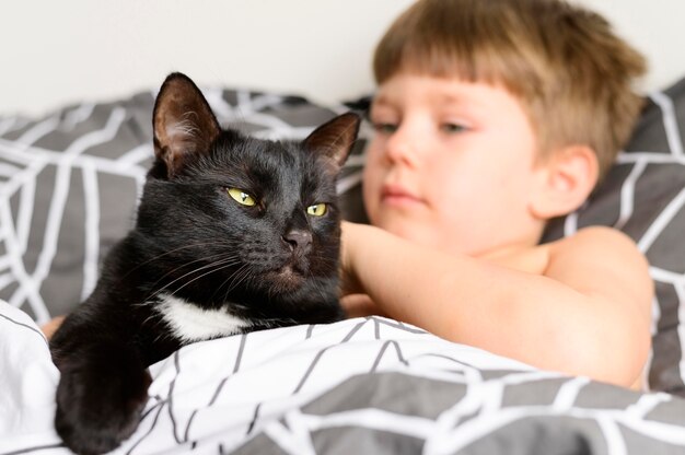 Adorable niño acariciando a su gato