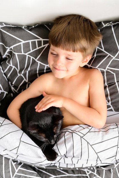 Adorable niño acariciando a su gato