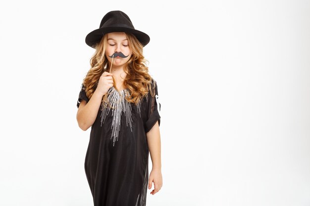 Foto gratuita adorable niño elegante posando con máscara de carnaval con los ojos cerrados.