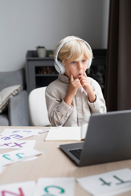 Adorable niño haciendo una sesión en línea de logopedia