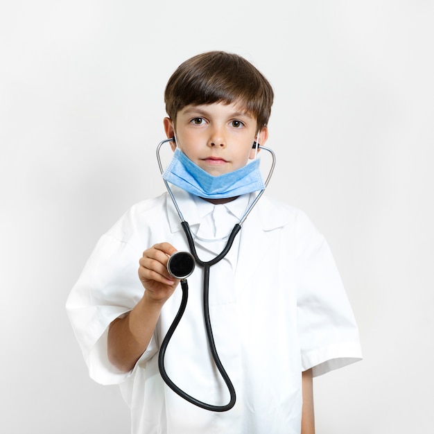 Foto gratuita adorable niño haciéndose pasar por médico