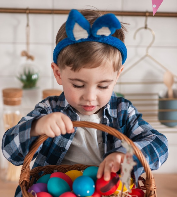 Adorable niño jugando con huevos de pascua