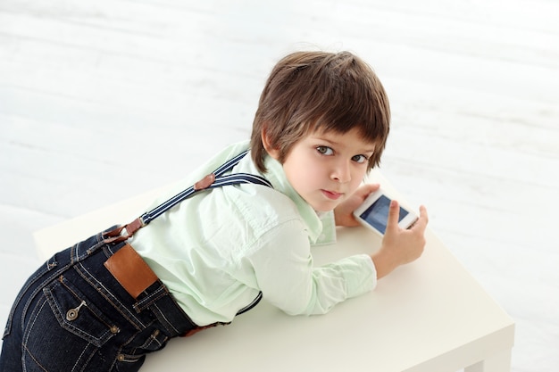 Adorable niño jugando con un teléfono inteligente