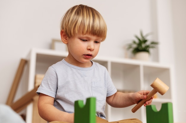 Foto gratuita adorable niño jugando con tiro medio de juguete