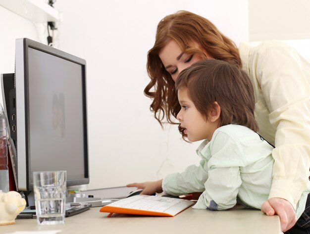 Adorable niño y madre usando una computadora