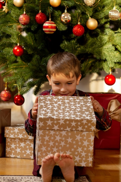 Adorable niño en la noche de Navidad en casa