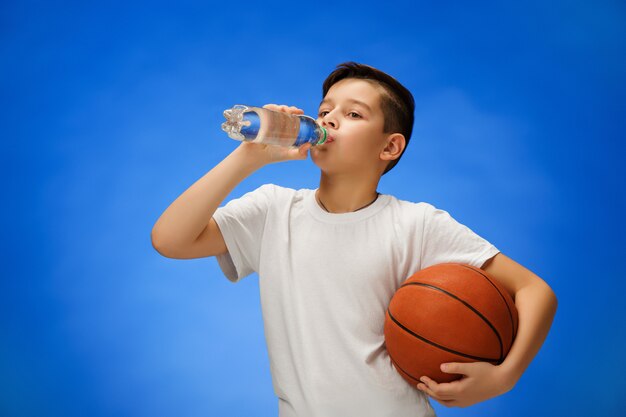 Adorable niño con pelota de baloncesto