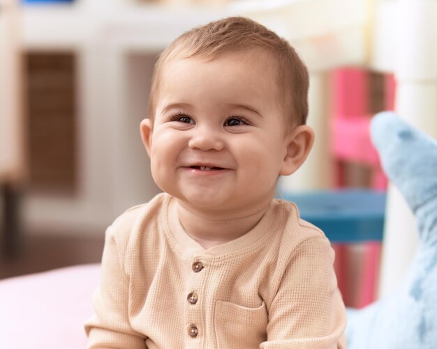 Adorable niño sonriente confiado sentado en el sofá en casa