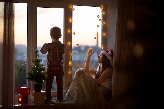 Adorable niño con su hermana en Navidad