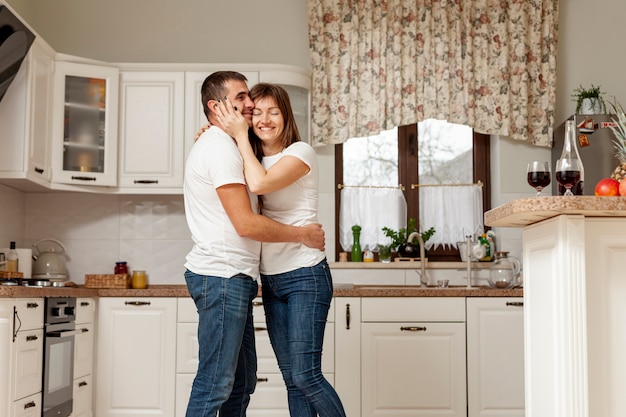 Adorable pareja abrazándose en la cocina