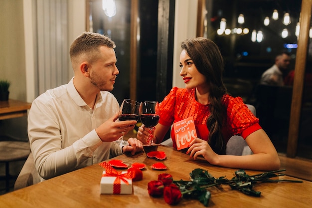 Adorable pareja amorosa con vino en el café