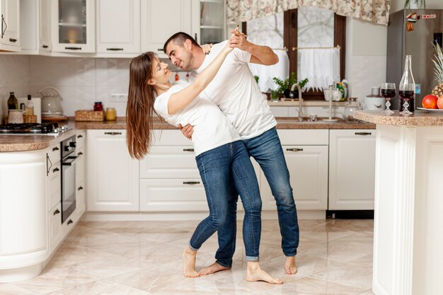 Adorable pareja bailando en la cocina