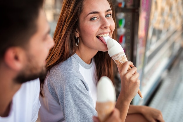 Adorable pareja comiendo helados en la feria