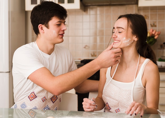 Adorable pareja joven jugando en la cocina