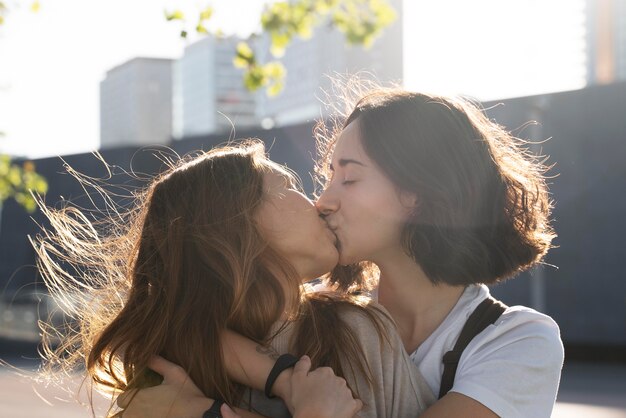 Adorable pareja de lesbianas besándose al aire libre