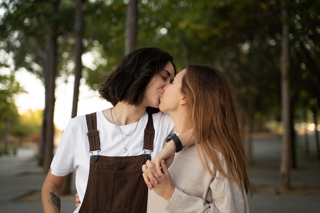 Adorable pareja de lesbianas besándose al aire libre