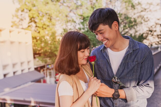 Adorable pareja con una rosa en las manos