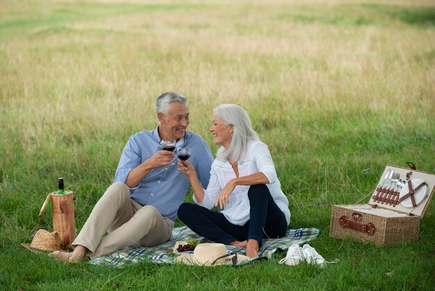 Adorable pareja senior haciendo un picnic al aire libre