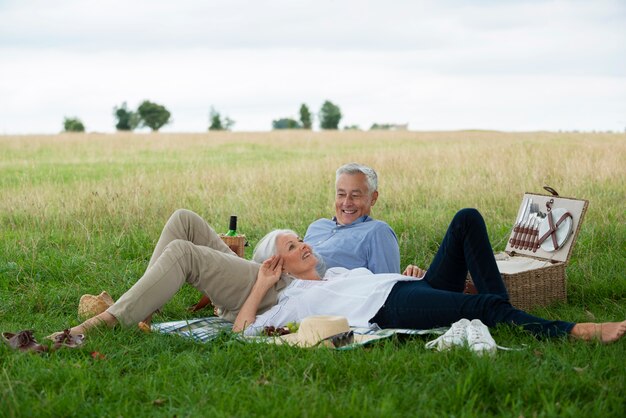 Adorable pareja senior haciendo un picnic al aire libre